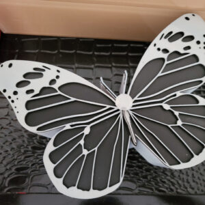 A 3d printed butterfly shaped jewelry box in top view picture placed on a dresser